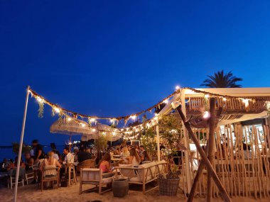 Golfe Juan, Fransa - 26 Haziran 2021: İnsanlar gün batımında plajın keyfini çıkarıyorlar. Fransız Rivierası yaz boyunca Avrupa 'nın en önemli tatil beldelerinden biridir..