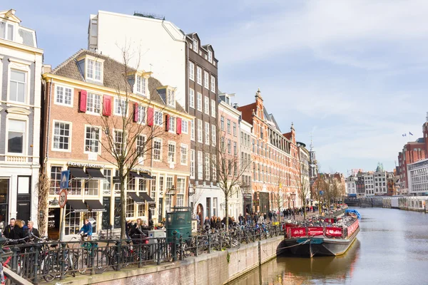 Amsterdam'da bir kanal tarafından yürüyen turist — Stok fotoğraf