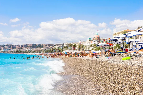 Turisté mají dobré počasí na pláži v Nice, Francie — Stock fotografie