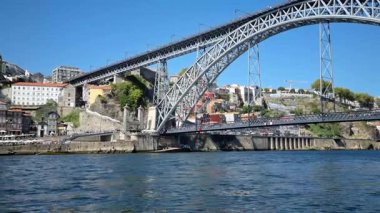 Porto, Portekiz - 11 Ağustos 2023: insanlar Dom Luis köprüsünü geçiyor. Çift katlı metal kemer köprüsü Porto ve Vila Nova de Gaia şehirleri arasındaki Douro Nehri boyunca uzanır..