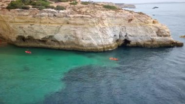 Algarve, Portekiz - 25 Ağustos 2023: İnsanlar sahildeki güzel bisikletçinin tadını çıkarıyorlar. Bölge, Avrupa 'nın en güzel 10 plajından ve dünyanın en iyi 100 plajından biri olarak kabul edilmektedir..