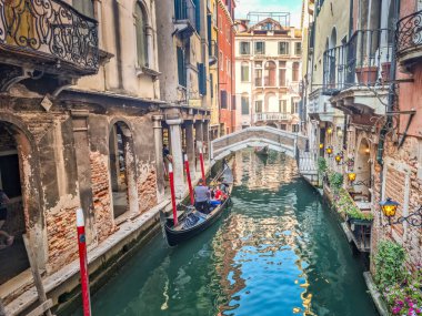 Venedik, İtalya - 20 Temmuz 2024: Kanalda gondolların tadını çıkaran turistler. Gondollar şehirdeki en popüler ve romantik ulaşım araçlarıdır..