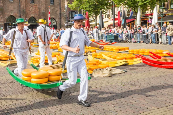 Träger mit vielen Käsesorten auf dem berühmten Markt von Alkmaar, den Niederlanden — Stockfoto