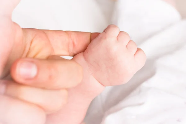 Baby fånga mammas finger — Stockfoto