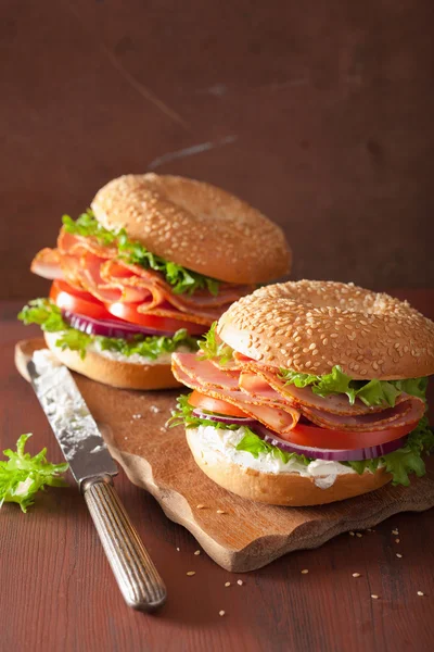 Sanduíche de presunto em bagel com creme de queijo cebola de tomate — Fotografia de Stock