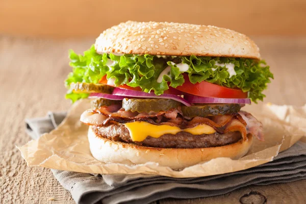 Bacon cheese burger with pickles tomato onion — Stock Photo, Image