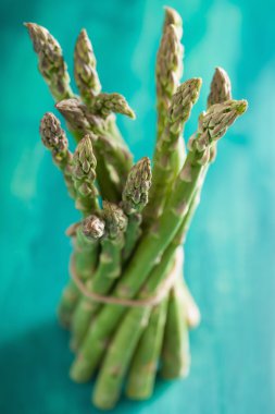 Grup turkuaz arka plan üzerinde taze kuşkonmaz