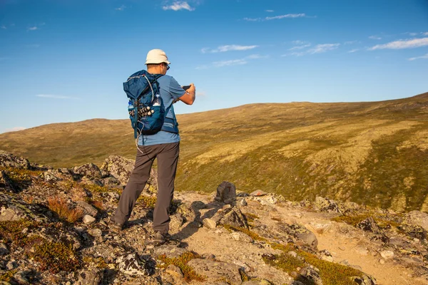 Excursionista tomando fotos del paisaje de montaña con teléfono inteligente — Foto de Stock