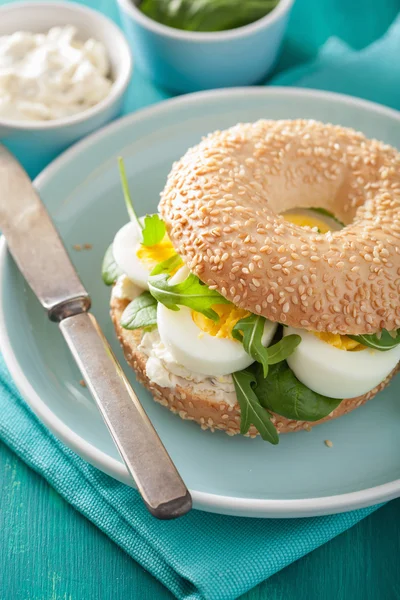 Sanduíche de café da manhã em bagel com queijo creme de ovo arugula — Fotografia de Stock