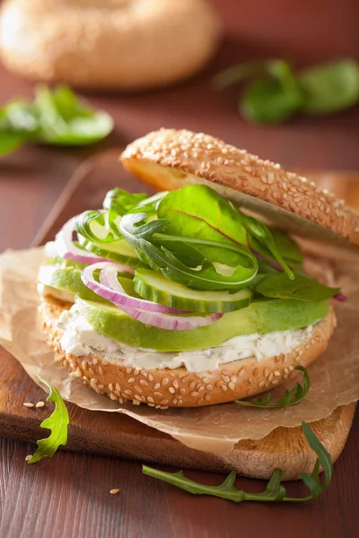 Bocadillo de aguacate en bagel con queso crema de cebolla pepino arugu — Foto de Stock