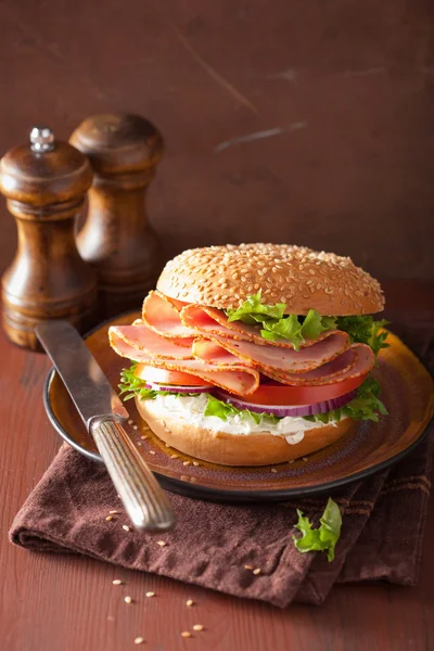Sanduíche de presunto em bagel com creme de queijo cebola de tomate — Fotografia de Stock