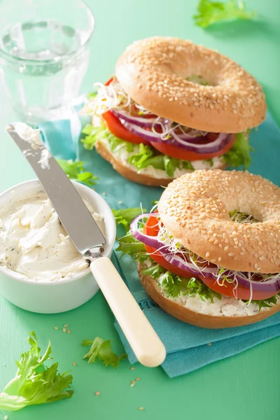 Tomat sandwich på bagel med flødeost løg salat lucerne - Stock-foto