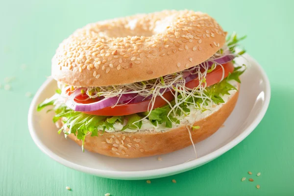 Sándwich de tomate en bagel con queso crema de cebolla lechuga alfalfa — Foto de Stock