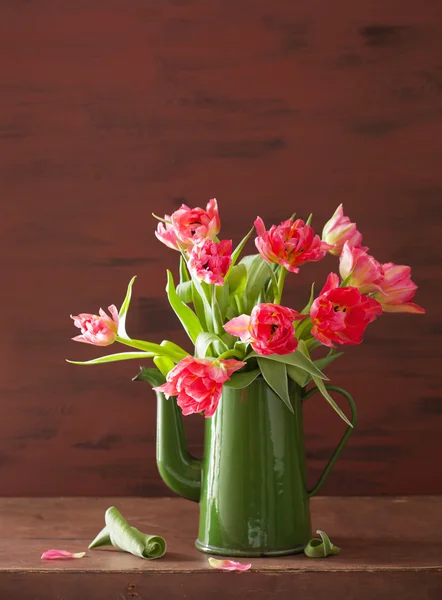 Lindo buquê de flores de tulipa rosa em bule verde — Fotografia de Stock