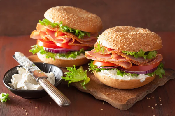 Ham sandwich on bagel with cream cheese tomato onion — Stock Photo, Image