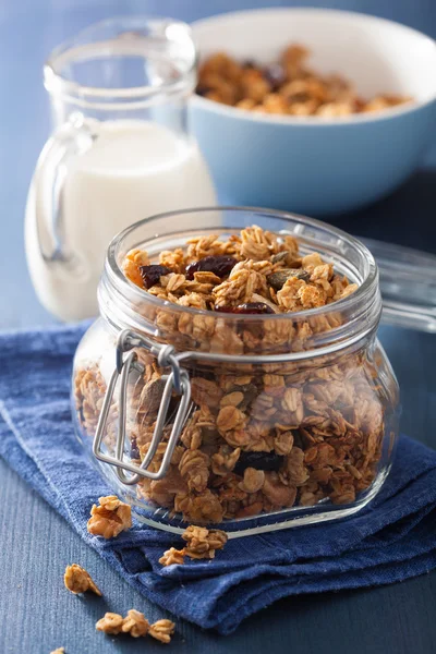 Homemade healthy granola in glass jar and milk — Stock Photo, Image