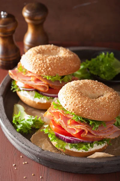 Sanduíche de presunto em bagel com creme de queijo cebola de tomate — Fotografia de Stock