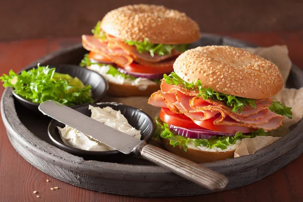 Sanduíche de presunto em bagel com creme de queijo cebola de tomate — Fotografia de Stock