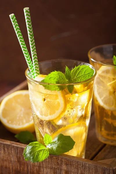 Чай со льдом с лимоном и мятой на темном деревенском фоне — стоковое фото