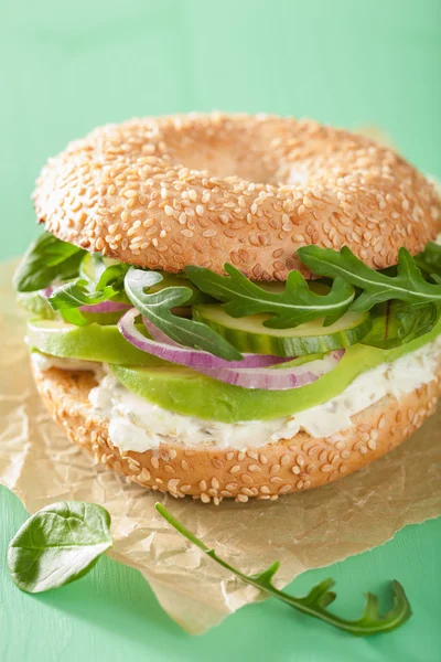 Sanduíche de abacate em bagel com creme de queijo cebola pepino arugu — Fotografia de Stock