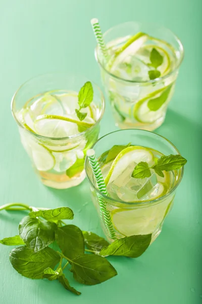 Mojito cocktail and ingredients over green background — Stock Photo, Image