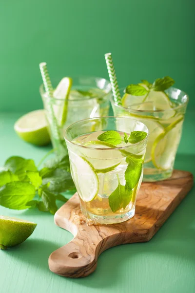 Mojito-Cocktail und Zutaten vor grünem Hintergrund — Stockfoto