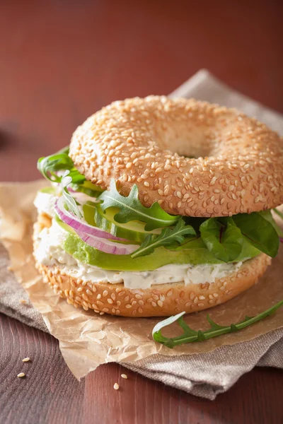 Sanduíche de abacate em bagel com creme de queijo cebola pepino arugu — Fotografia de Stock