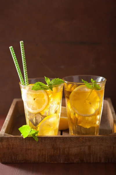 Té helado con limón y menta sobre fondo rústico oscuro —  Fotos de Stock