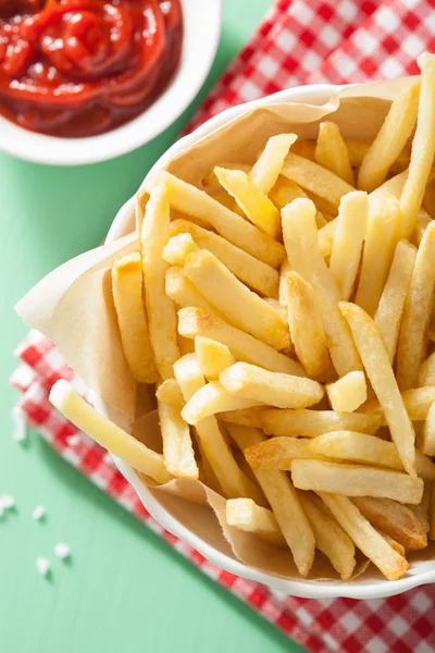 Batatas fritas com ketchup sobre fundo verde — Fotografia de Stock