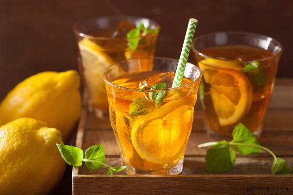 Té helado con limón y menta sobre fondo rústico oscuro —  Fotos de Stock