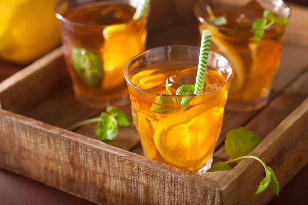 Té helado con limón y menta sobre fondo rústico oscuro — Foto de Stock