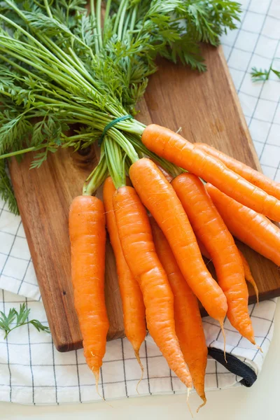 Légumes aux carottes crues sur planche à découper en bois — Photo