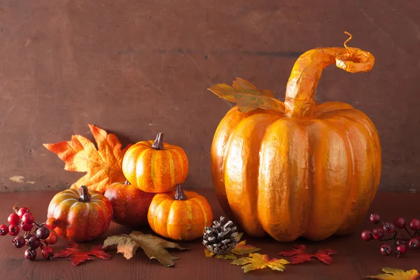 Dekorativer goldener Pappmaché-Kürbis und Herbstblätter für hal — Stockfoto