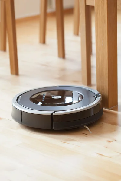 Robotic vacuum cleaner on laminate wood floor smart cleaning tec — Stock Photo, Image