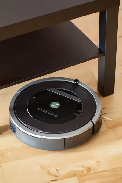 Robotic vacuum cleaner on laminate wood floor smart cleaning tec Royalty Free Stock Images