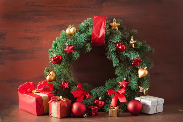 Caixa de presente de Natal vermelho e dourado e coroa de flores de decoração — Fotografia de Stock