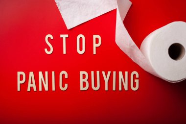 Paniğe kapılıp tuvalet kağıdı almayı kes. Kırmızı arkaplan koronavirüs covid-19 'un tahta harfini yaz.