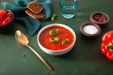 Yeşil arka planda domates ve dolmalık vejetaryen çorbası.