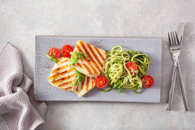 Ketogenik paleo diyeti öğle yemeği. Halloumi peyniri, roka soslu sarımsaklı kabak ve domates.