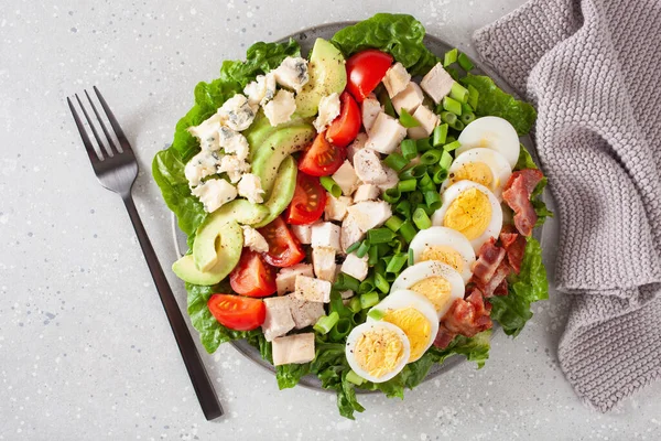 healthy American Cobb salad with egg bacon avocado chicken tomato. hearty keto low carb diet