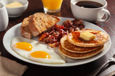 Geleneksel Amerikan kahvaltı yumurtaları pastırmalı krep ve tost.