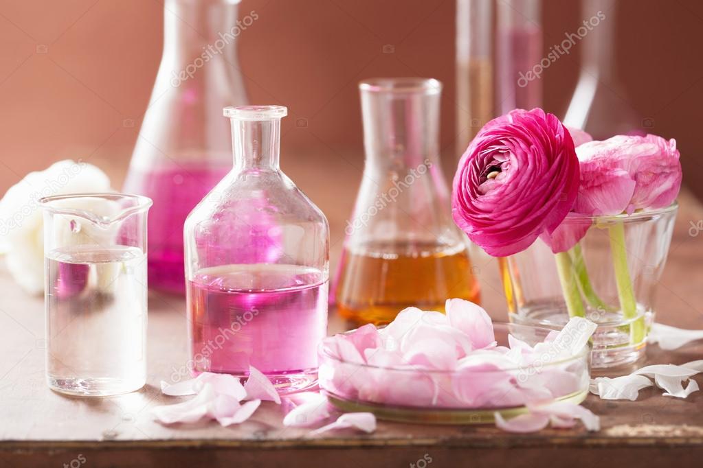 alchemy and aromatherapy set with ranunculus flowers and flasks 