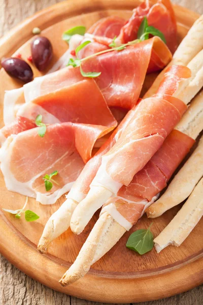 Prosciutto ham and grissini bread sticks. italian antipasto — Stock Photo, Image