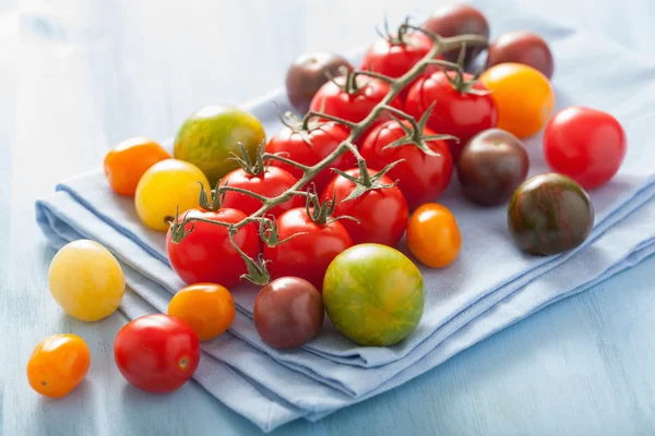 Barevné rajčata přes modrý ubrousek — Stock fotografie