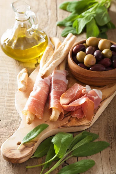 Prosciutto crudo grissini bastoncini di pane olio d'oliva — Foto Stock