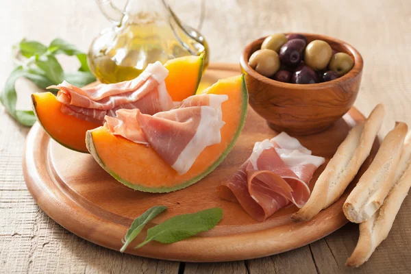 Cantaloupe melon with prosciutto and olives. italian appetizer — Stock Photo, Image