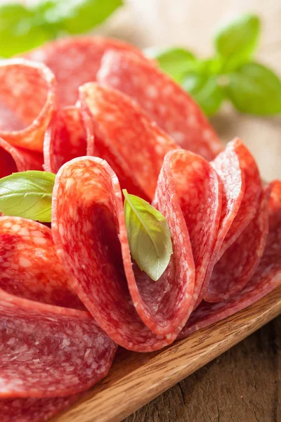 Fette di salame in piatto di legno — Foto Stock