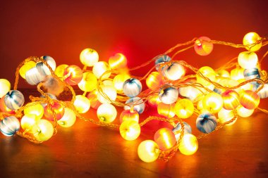 kırmızı bir arka plan üzerinde yanan Noel ışıkları 