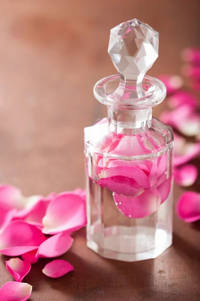 Μπουκάλι άρωμα και ροζ ροδαλά λουλούδια. σπα αρωματοθεραπείας — Φωτογραφία Αρχείου