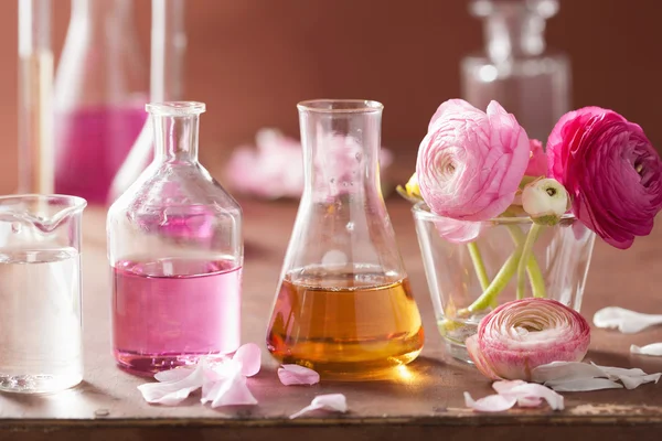 Ensemble alchimie et aromathérapie avec fleurs et flacons de ranunculus — Photo